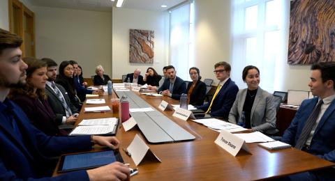 Professionally dressed Rines Angel Fund students sit around a board table in a Paul College conference room pitching a new investment to their committee.