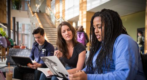 Two female students collaborating on a project in the Paul College Great Hall