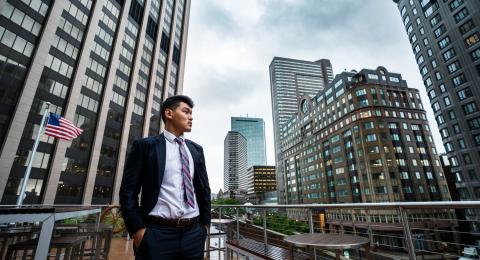 Ashim Gurung '22 stands outside along a Boston skyline