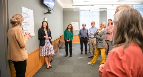 Cohort of employees gather in a classroom listening to a UNH Paul College faculty provide leadership development training