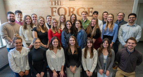 A group of students in Voice Z digital pose in their workspace alongside professors and professional mentors.