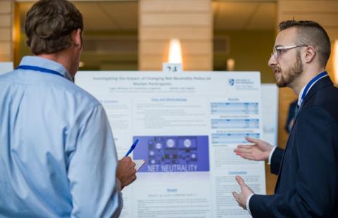 URC presenter explaining their poster to a judge