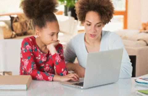 black mother helping child with homework getty
