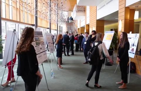 A photo of students presenting research projects in Paul College's great hall