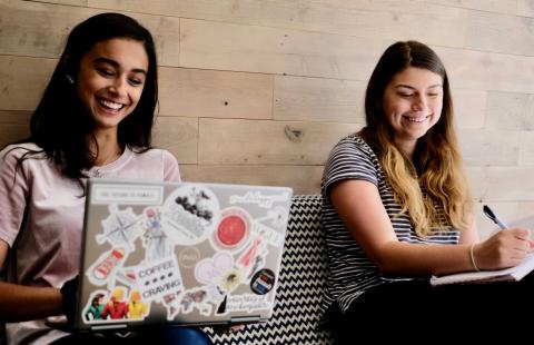 Students laughing in the more casual study area in the forge