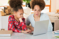 black mother helping child with homework getty