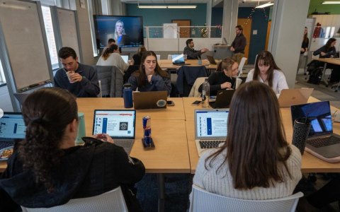 Voice Z Digital students work on their laptops in their modern classroom space.