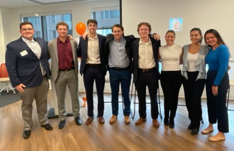 A group of professionally dressed students pose at the sales role-playing competition