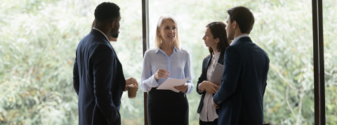 Multi ethnic students surround middle-aged professional and ask her questions. Listen guidance feels focused and interested.