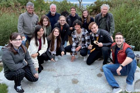 A large group of students enrolled in the Shaw Innovation Explorers Program smiles at the camera in a group photo.