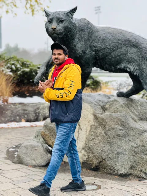 nagateja reddy, a graduate of UNH's master's in finance program, standing in front of the UNH Wildcat statue