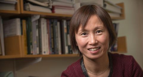Shuili Du close up with bookshelves behind her