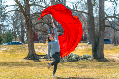Pinar Gokalp '21 A student swinging a large red color guard flag