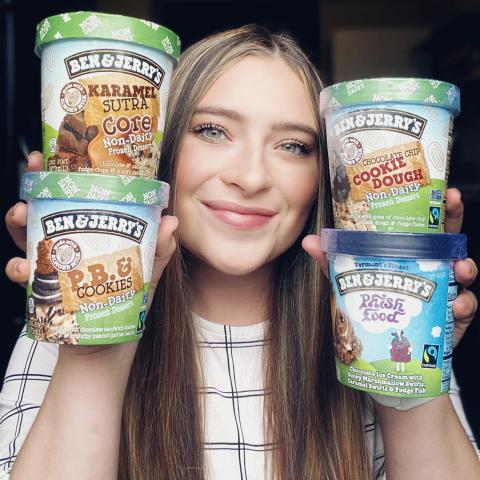Jordan Bohan holds pints of Ben & Jerry's around her face. A female student holds pints of ice cream up next to her face
