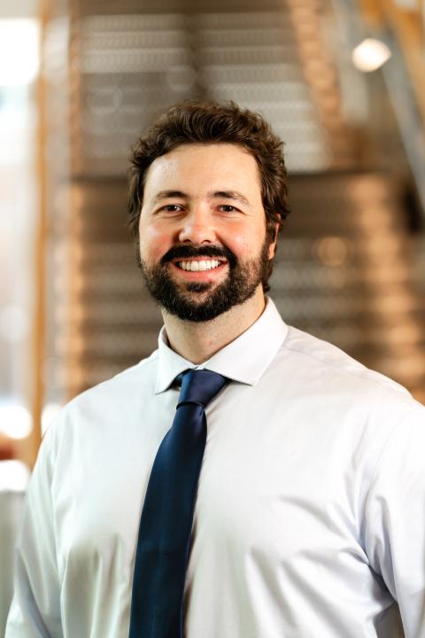 Headshot of Cayce Jones, male, with dark hair and beard, dressed professionally