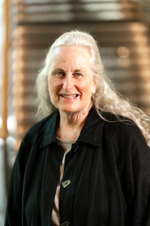 Woman with long gray hair in a black coat
