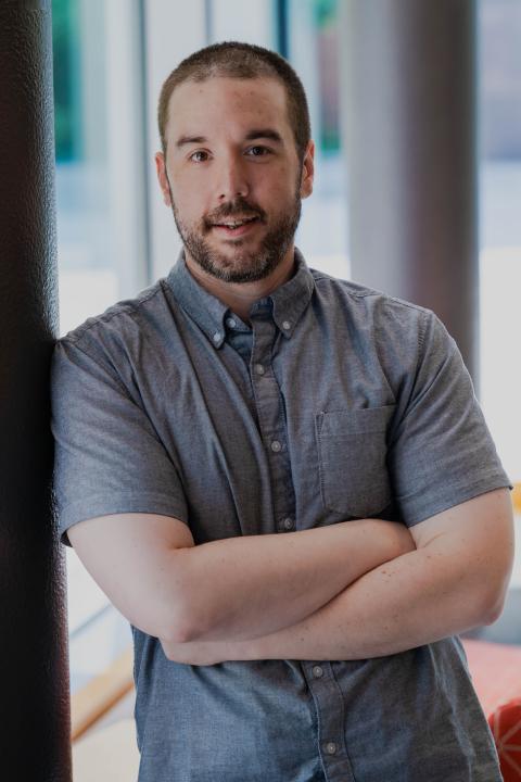 Aaron Sanborn leans against a wall in the great hall